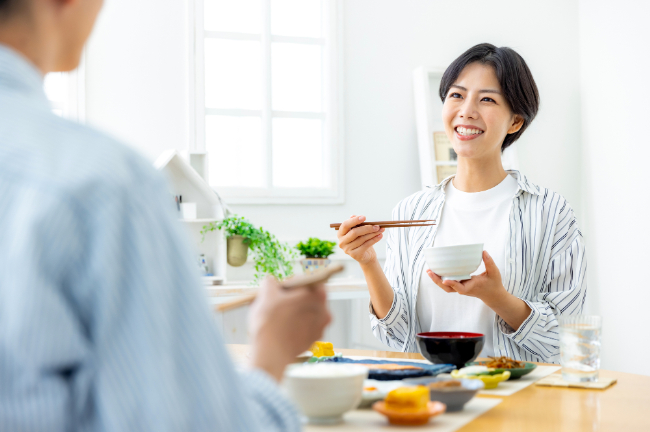 根管治療をして笑顔で食事をする女性